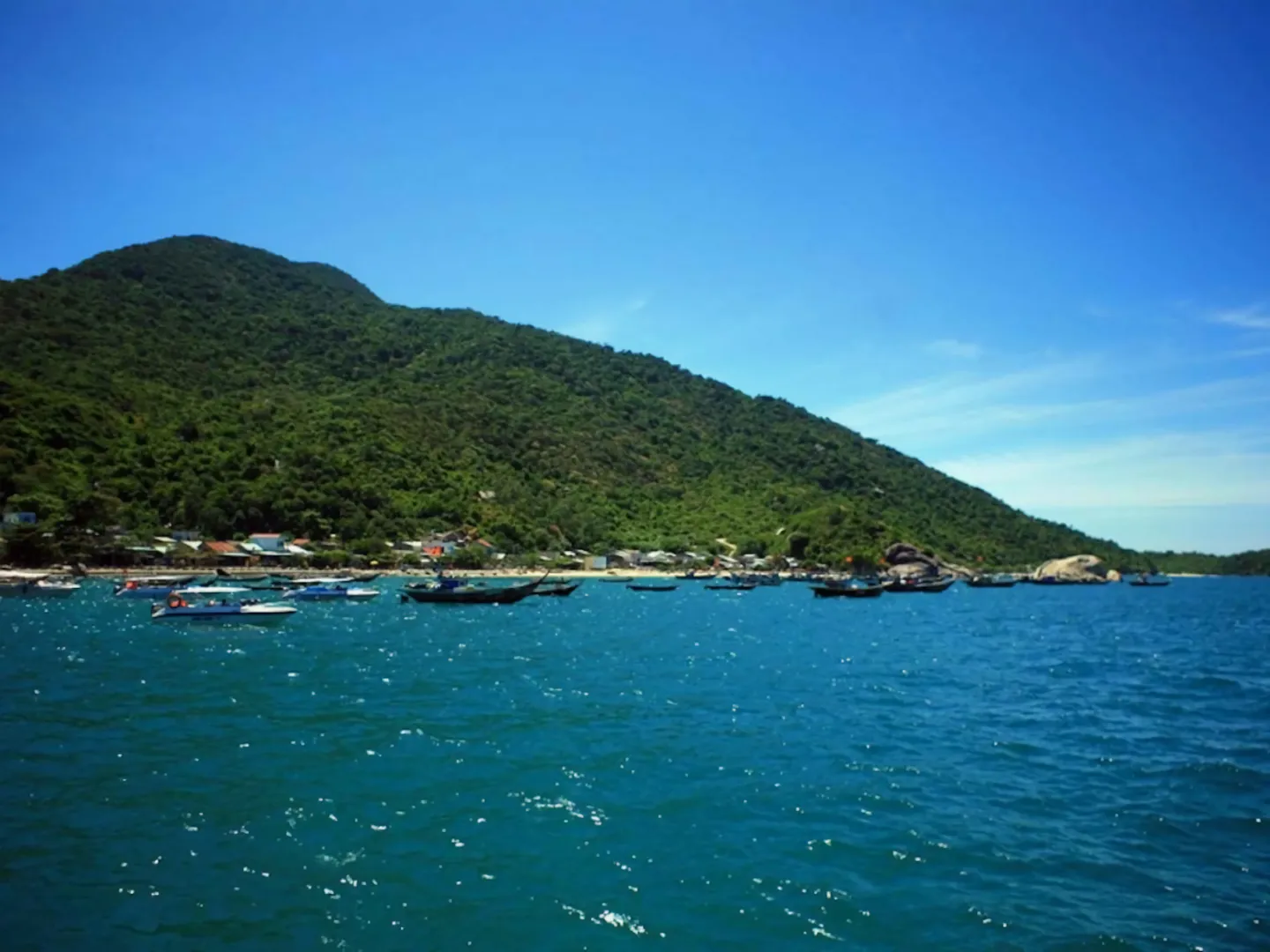  Hills covered with tropical flora and blue water on Cham Island off Hoi An, a popular holiday destination in Vietnam 