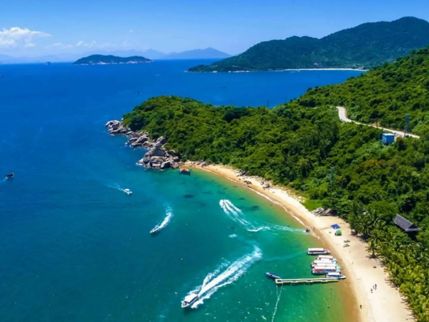  Aerial shot of a tropical beach with turquoise water and palm trees on Cham Island off Hoi An, a popular holiday destination in Vietnam 