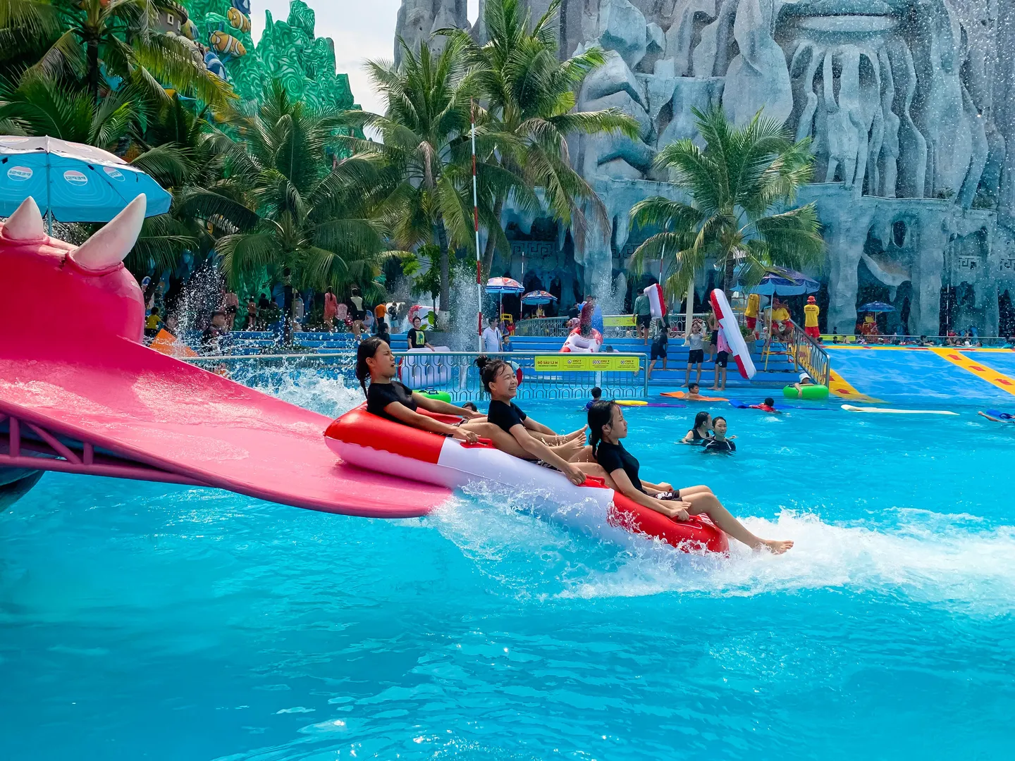  Visitors sliding off fast a water slide in a pool in a water park in Suoi Tien theme park located in Ho Chi Minh City, a popular holiday destination in Vietnam 