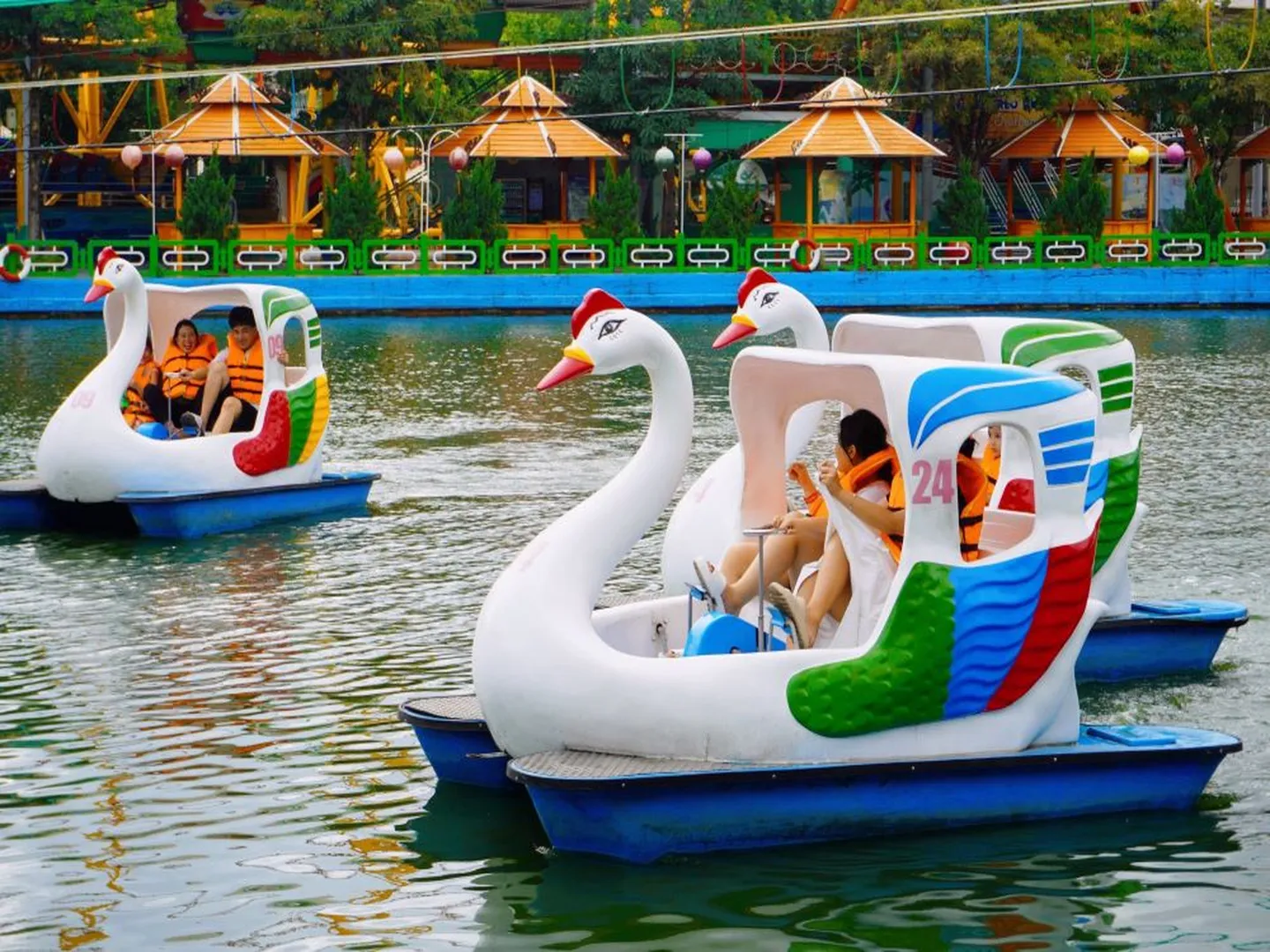  Visitors enjoying a ride in a swan-shaped boats in a lake in Suoi Tien theme park located in Ho Chi Minh City, a popular holiday destination in Vietnam 